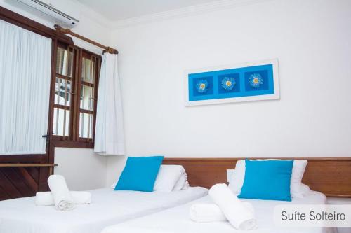 2 camas en una habitación con almohadas azules y blancas en Porto seguro Residencial Jerusalem 1, en Porto Seguro