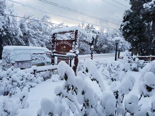 a sign covered in snow in front of a street at De las Rosas Bariloche in San Carlos de Bariloche