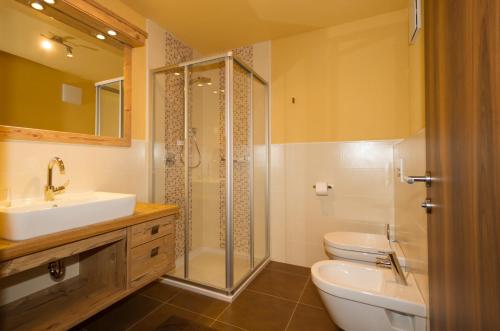 a bathroom with a sink and a toilet and a shower at Ferienwohnung & Spa Access Zimmerhofer in Cadipietra