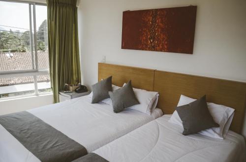 two twin beds in a room with a window at Llanogrande Airport by Bernalo Hotels in Rionegro