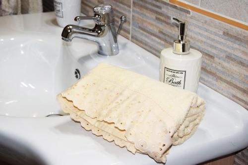 a bathroom sink with a towel and a bottle of soap at Appartamenti Da Vincenza in Santa Maria Navarrese