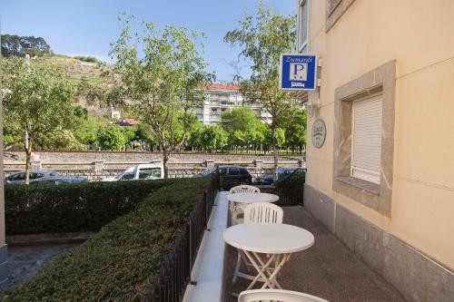 a row of tables and chairs on a sidewalk next to a building at Pensión Zumardi in Deba