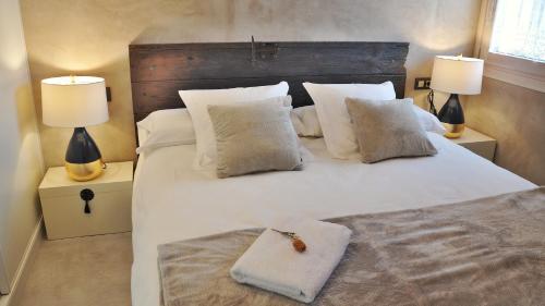 um quarto com uma grande cama branca e 2 candeeiros em Casa Rural Cirerer em San Lorenzo de Morunys