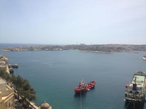 two red boats in a large body of water at Grand Harbour Hotel in Valletta