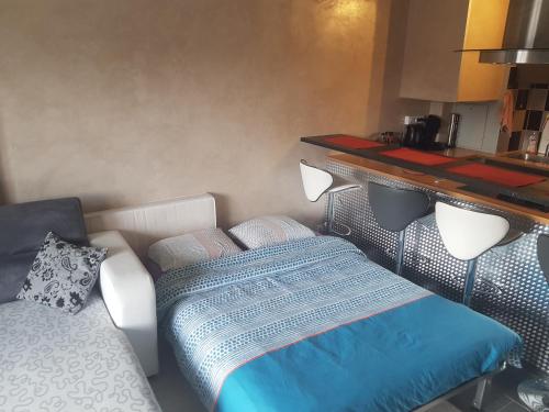 ein Schlafzimmer mit einem Bett und einem Sofa darin in der Unterkunft studio meublé avec balcon in Arcueil