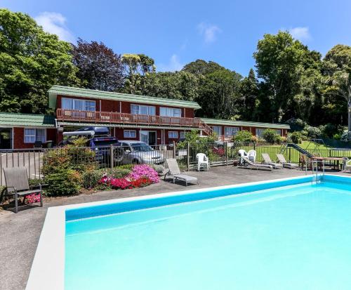 - une piscine en face d'une maison dans l'établissement Flamingo Motel, à New Plymouth