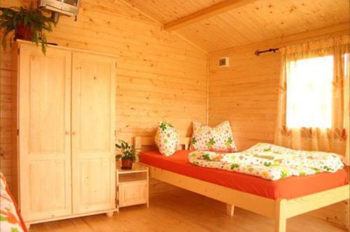 a bedroom with a bed in a wooden room at Csatári Pensiune Praid in Praid