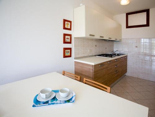 una cocina con dos tazas y un plato en una encimera en Apartments in Bibione 24550, en Bibione