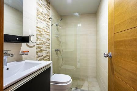 a bathroom with a shower and a toilet and a sink at Villa Palmera XVIII in Santo Domingo