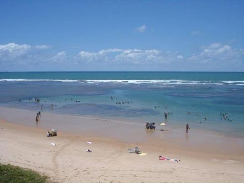 a group of people in the water at the beach at SUMMER HOUSE GENIPABU in Guarajuba