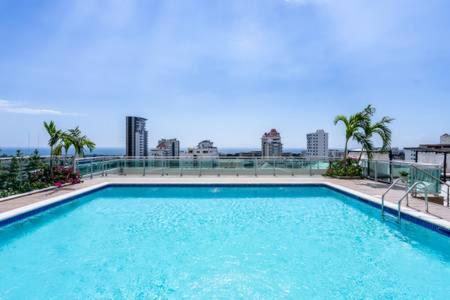 una gran piscina con una ciudad al fondo en Villa Palmera XVIII, en Santo Domingo