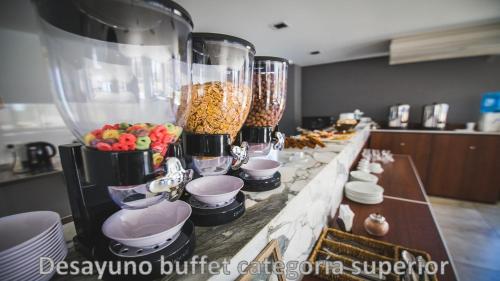 a buffet line with fruit and food in a kitchen at Hotel AATRAC in Mar del Plata