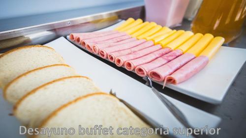 a bunch of hot dogs on a grill with bread at Hotel AATRAC in Mar del Plata