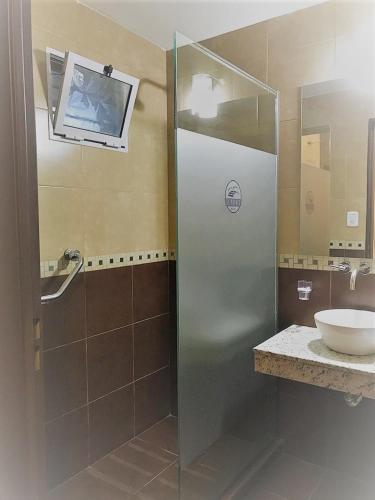 a shower with a glass door in a bathroom at Hostería Boutique El Puente Adults Only in Merlo