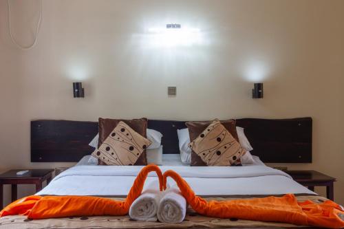a bed with an orange blanket and a stuffed animal on it at Chez Bea Luxury Villa in Baie Sainte Anne