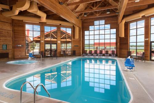 a swimming pool in a large room with windows at Arrowwood Resort at Cedar Shore in Oacoma
