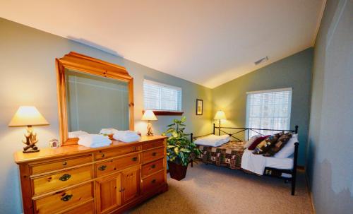 a bedroom with a bed and a dresser with a mirror at Mt. Maplewood Split Chalet in Pocono Lake