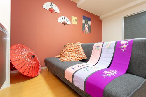 a living room with a couch and an umbrella at Miyabiro 105 in Kyoto