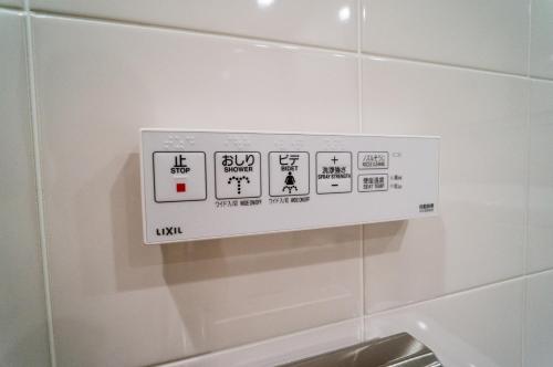 a white sign on a wall in a bathroom at Hotel New Palace in Shingu