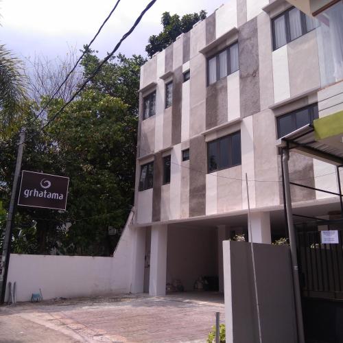 a building with a sign on the side of it at Grhatama Guest House in Yogyakarta