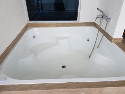 a bath tub in a bathroom with a window at Departamento frente al mar Grand Diamond in Tonsupa