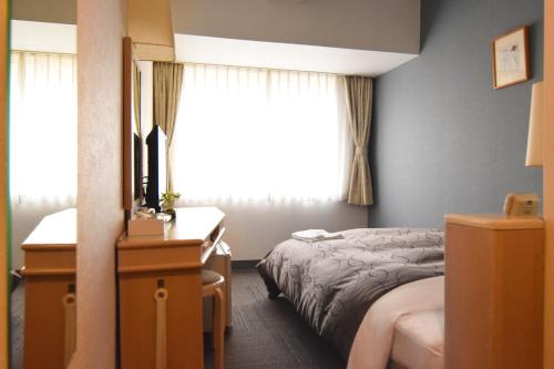a hotel room with a bed and a window at Hotel Raffinato Sapporo in Sapporo