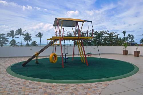 un parque infantil con un tobogán en un green en Solaris Residencial Clube, en Ilhéus