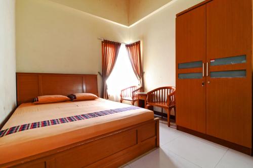Schlafzimmer mit einem Bett, einem Schreibtisch und einem Fenster in der Unterkunft Bedur Homestay Syariah in Bekasi
