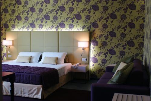 a hotel room with a bed and a couch at El Homs Palace Hotel in Comiso