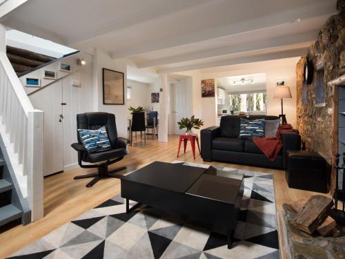 a living room with a couch and a chair at Gumnut Cottage Daylesford in Daylesford
