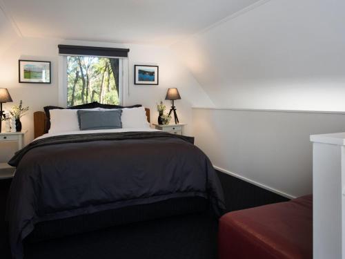 a bedroom with a large bed and a window at Gumnut Cottage Daylesford in Daylesford