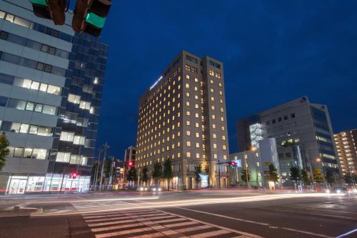 Un palazzo alto in una strada di città di notte di President Hotel Mito a Mito