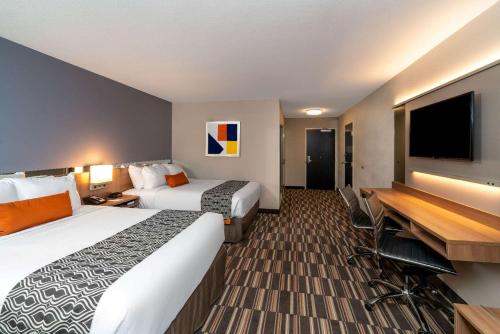 a hotel room with two beds and a flat screen tv at Microtel Inn & Suites by Wyndham Carlisle in Carlisle