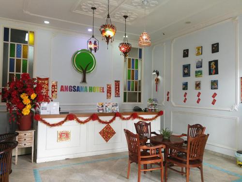 uma sala de jantar com mesa e cadeiras em Angsana Hotel Melaka em Malaca
