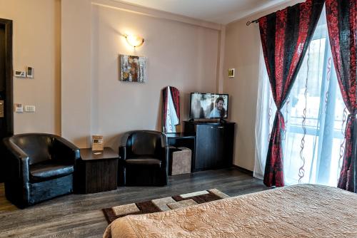 a hotel room with a bed and a desk and chair at Vila Ana in Băile Govora