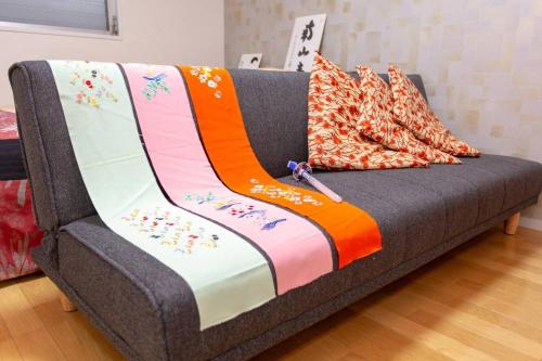 a couch with a blanket on top of it at Miyabiro 106 in Kyoto
