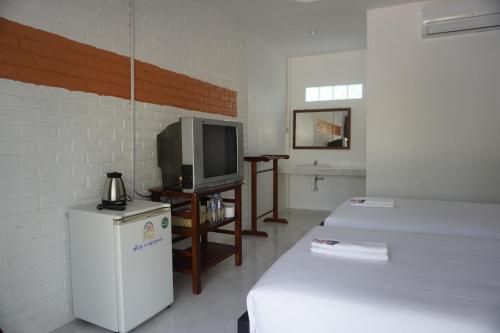 a living room with a refrigerator and a tv at Samnaree Garden House in Ban Phae Mai