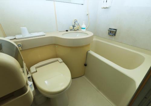 a small bathroom with a toilet and a sink at Kawagoe Daiichi Hotel in Kawagoe