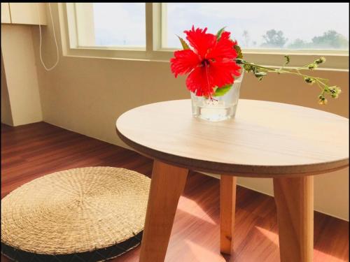 a vase with a red flower sitting on a table at Full Moon Resort in Hengchun