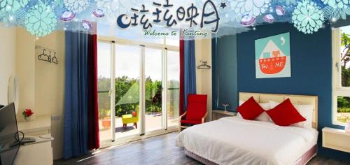a bedroom with a bed and a large window at Full Moon Resort in Hengchun