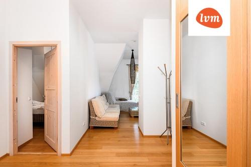 pasillo con sala de estar con silla y espejo en Villa Lehe Ranna Apartment, en Pärnu