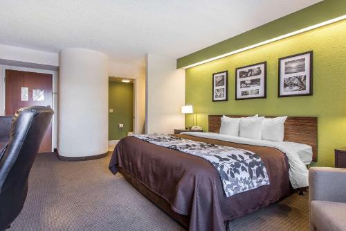 a hotel room with a large bed and green walls at Sleep Inn & Suites North Augusta in North Augusta
