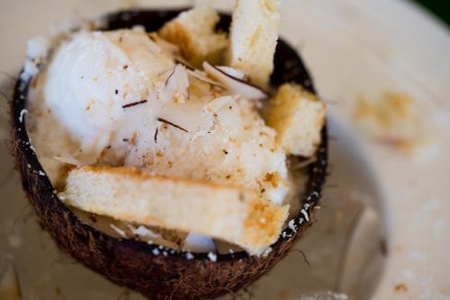 a piece of cake on a plate with a spoon in it at Le Nautique Waterfront Hotel La Digue in La Digue