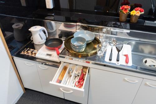 a kitchen counter with dishes and utensils on it at Grande Famille Shimanouchi Dotonbori Condo in Osaka