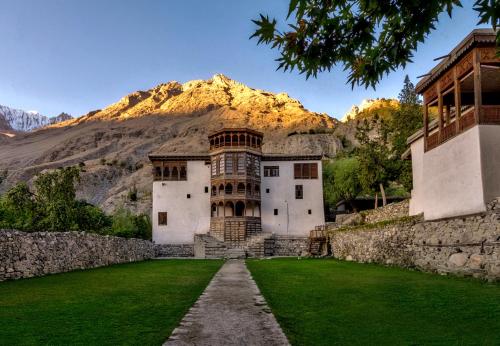 an old building with a mountain in the background at Serena Khaplu Palace in Khaplu