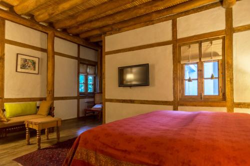 a bedroom with a bed and a tv on the wall at Serena Khaplu Palace in Khaplu