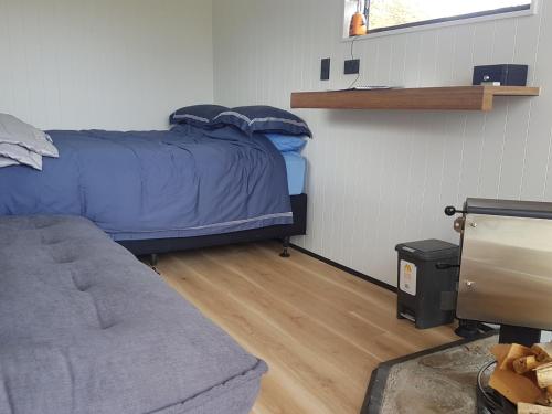 1 dormitorio con 1 cama y 1 sofá en Lake Stella Mountain Huts, en Mt Lyford