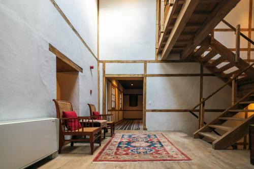 a hallway with a staircase and chairs and a rug at Serena Khaplu Palace in Khaplu