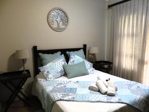 a bedroom with a bed with two stuffed animals on it at Ash River Lodge in Clarens