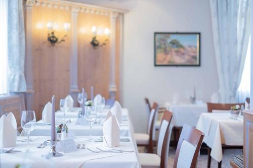 a dining room with white tables and chairs at Thermenhotel Apollo in Bad Füssing